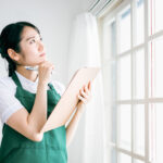 窓をチェックする女性